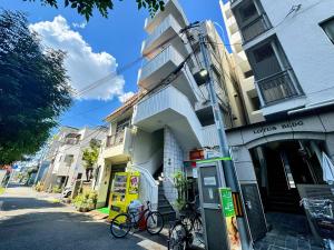 um edifício com duas bicicletas estacionadas em frente em 駅徒歩1分2DKで広々快適5階エレベーターなし 天王寺4分心斎橋13分HANAInn em Osaka