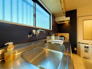 uma cozinha com pia de aço inoxidável e janela em 駅徒歩1分2DKで広々快適5階エレベーターなし 天王寺4分心斎橋13分HANAInn em Osaka mais 48 fotografias