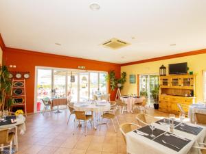 a restaurant with tables and chairs in a room at Apartamento Oásis Parque 1 in Portimão
