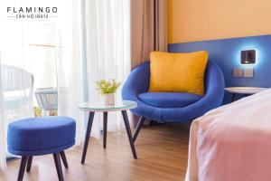 ein Zimmer mit zwei Stühlen und einem Tisch und einem Bett in der Unterkunft FLAMINGO IBIZA HAI TIEN - Resort 5 Sao in Thanh Hóa