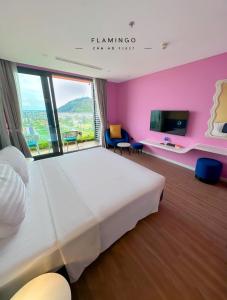 ein Schlafzimmer mit einem großen Bett und einem großen Fenster in der Unterkunft FLAMINGO IBIZA HAI TIEN - Resort 5 Sao in Thanh Hóa