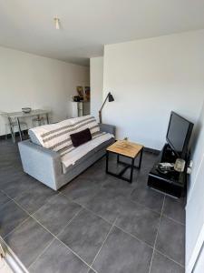 una sala de estar con una cama y una mesa en Studio spacieux en centre Ville, en Calvi