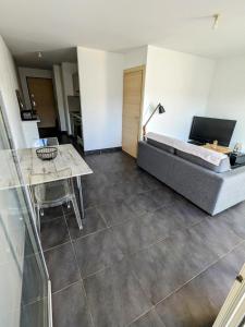 una sala de estar con una cama y una mesa en Studio spacieux en centre Ville, en Calvi 4 fotos más