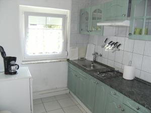a kitchen with green cabinets and a sink and a window at Ferienhaus Nr1 in Balatonszárszó