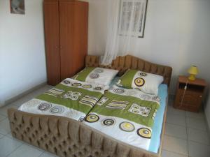 a bed with green and white blankets on it at Ferienhaus Nr1 in Balatonszárszó +2 photos