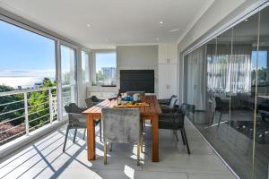 una cucina e una sala da pranzo con tavolo e sedie di Kings Beach Guest House a Port Elizabeth