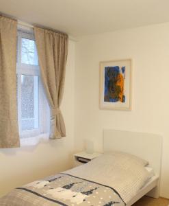 a bedroom with a bed and a window at Haus Roy - Ferienwohnung Erdgeschoß in Zülpich