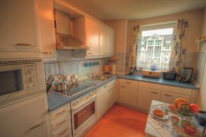 a kitchen with white cabinets and a sink and a window at Ostseeaussicht in Eckernförde