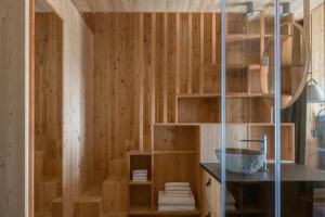 a bathroom with wooden walls and a shower with a sink at Zallinger Dolomites in Seiser Alm 