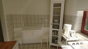 una cocina con dos taburetes y un armario con platos en Ferienhaus Gerasymchuk, en Eckernförde