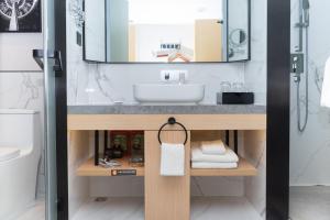 a bathroom with a sink and a mirror at Guangzhou Baiyun Airport COCO Hotel T2 Terminal Store Canton Fair Free Shuttle Bus in Huadu