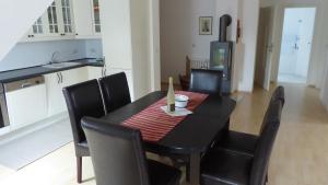 une table de salle à manger noire avec des chaises noires dans une cuisine dans l'établissement Galerie D OST, à Gingst