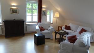 a living room with two white chairs and a table at Galerie D OST in Gingst
