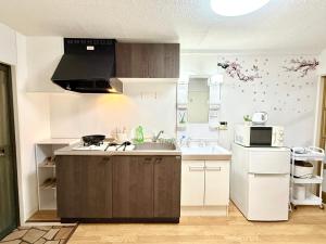 a kitchen with a sink and a microwave at Shinjuku Wasedaハウス T4 in Tokyo +24 photos