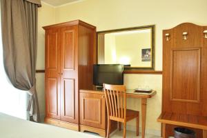 a bedroom with a desk with a television and a mirror at Ghv Rooms Roma in Rome
