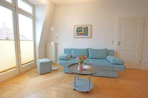 ein Wohnzimmer mit einer blauen Couch und einem Tisch in der Unterkunft Villa Quisisana in Ahlbeck + 8 Fotos