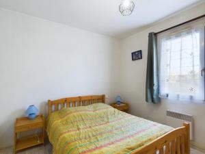 ein Schlafzimmer mit einem Bett und einem Fenster in der Unterkunft Maison de vacances pour 4, St-Hilaire-de-Riez in Saint-Hilaire-de-Riez