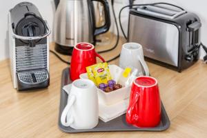 a table with a tray of food and two red cups at Casaminnie - Appartement à 8 min de Disneyland Paris in Bussy-Saint-Georges +17 photos