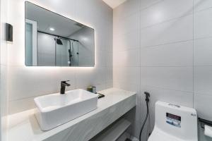 a white bathroom with a sink and a mirror at ANNIE HOUSE Nha Trang- One bedroom cozy apartment near the beach & Tram Huong Tower with big promo in Nha Trang