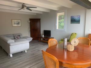 a living room with a table and a couch at Vacances de rêve vue mer et montagne in Brando