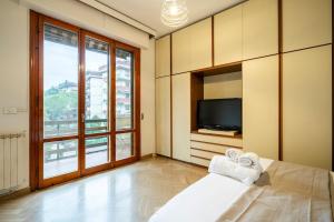 Una habitación con una cama y un televisor y una ventana. en Near Airport 8 Guests - Big Elegant Apartment, en Florencia