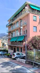 a pink building with cars parked in front of it at Le Caravelle in Rapallo
