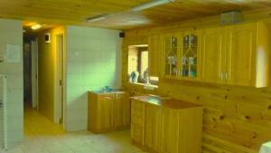 una cucina con mobili in legno e un lavello di Leon's farmstead in the countryside, Sauna and Jacuzzi for 16-23 people a Užuperkasis
