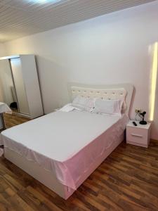 a bedroom with a large white bed with white sheets at Vila cu garsoniere in Bucharest