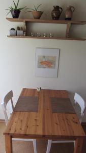 ein Holztisch mit weißen Stühlen und ein Holztisch mit einem Holztisch in der Unterkunft Kuschelkoje 2 Edition in Eckernförde