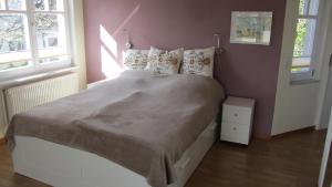 ein Bett in einem Schlafzimmer mit einer rosa Wand in der Unterkunft Kuschelkoje 2 Edition in Eckernförde