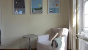 einen weißen Stuhl und einen Tisch in einem Zimmer in der Unterkunft Kuschelkoje 2 Edition in Eckernförde + 7 Fotos