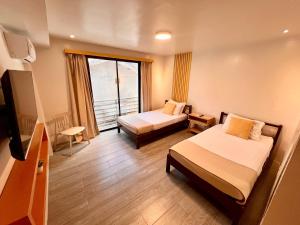a hotel room with two beds and a window at La Palme in El Nido
