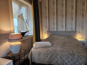 a bedroom with a bed and a sailboat in a window at Sea Breeze apartment Hellevoetsluis in Hellevoetsluis