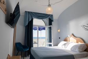 1 dormitorio con cama y ventana con vistas al océano en Hotel Punta Imperatore, en Isquia 37 fotos más