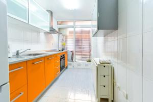a kitchen with orange cabinets and a sink at PLAYA LEVANTE céntrico y con Parking By Aloha Palma in Águilas