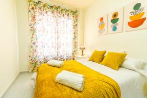 a bedroom with a large bed with yellow sheets and a window at PLAYA LEVANTE céntrico y con Parking By Aloha Palma in Águilas