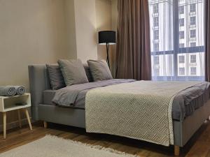 een slaapkamer met een bed en een groot raam bij Residence Apartment Osh Шикарные апартаменты в самом Элитном районе города Ош in Osh