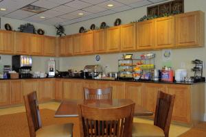 a kitchen with a table and chairs and a refrigerator at Country Inn & Suites by Radisson, Orangeburg, SC in Orangeburg