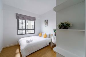 a white bedroom with a bed and a window at Solena Landmark Riverside Apartment in Mậu Lâm (3) +10 photos