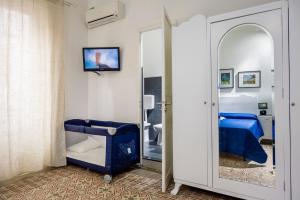 Pokój z sypialnią z lustrem i łóżkiem w obiekcie Le Case di Katy w mieście Castellammare del Golfo