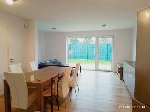 eine Küche und ein Esszimmer mit einem Holztisch und Stühlen in der Unterkunft Neues 3ZimerHaus Düsseldorf Airport &Messe in Ratingen