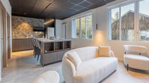 a living room with a couch and a chair and a kitchen at Le Dauphiné 2 - Allevard in Allevard
