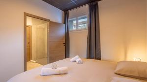 a bedroom with a bed with towels on it at Le Dauphiné 2 - Allevard in Allevard