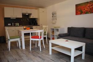 a living room with a couch and a table and a kitchen at Ferienwohnungen In der Acht in Idar-Oberstein