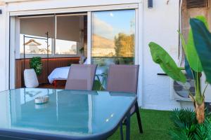 a glass table and chairs on a patio at AIOLOS Rooftop suite centre GLYFADA in Athens