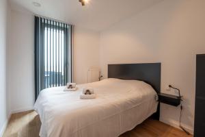 オーステンデにあるNew apartment close to the beach with garageの白いベッドとタオルが2枚置かれた寝室