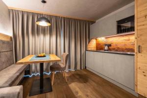 a dining room with a table and a kitchen at Apartments Mia Cô in Antermoia
