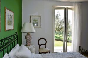 a bedroom with a bed and a chair and a window at Villetta Giare in Posina