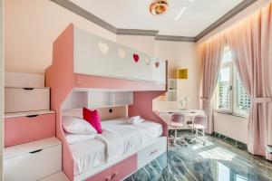 1 dormitorio con litera rosa y escritorio en GuestReady - Palm Jumeirah delight, en Dubái