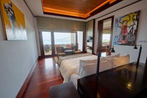 a bedroom with a large bed and a large window at Villa 29 Montebello Andara Resort Villas in Kamala Beach